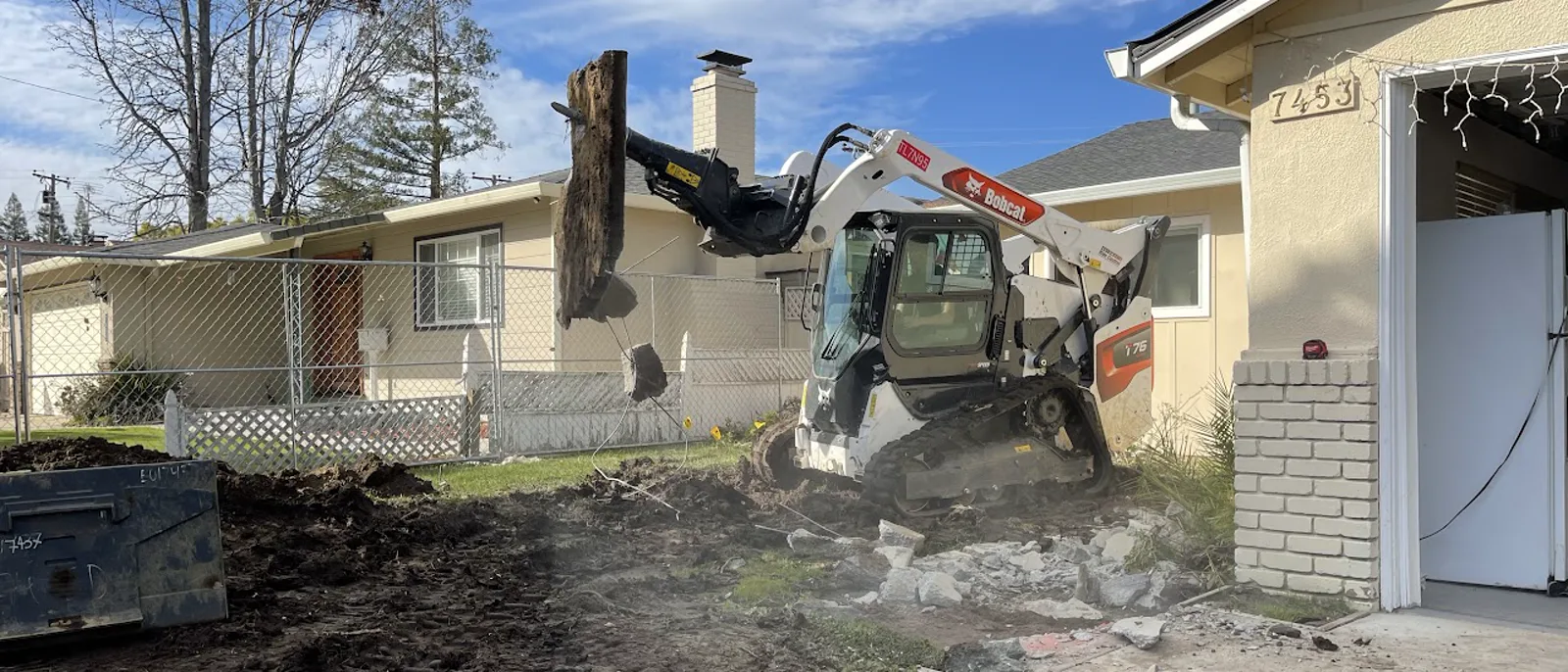Excavator working beside a residential home